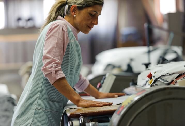 Un femme qui ponce le cuir